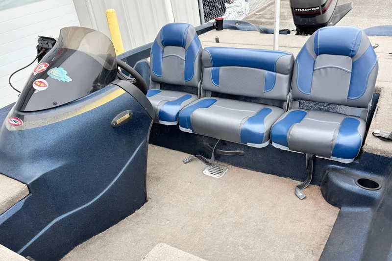 Slide: The Image of 1998 Nitro 800 LXS boat interior with blue and gray seating, steering console, and carpeted floor. - 5