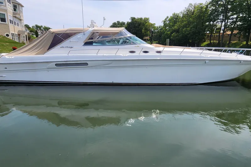 Slide: The Image of 1998 Sea Ray 630 Super Sun Sport yacht docked on calm water. - 0