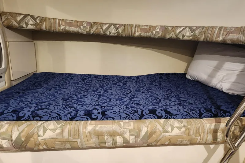 Slide: The Image of Bunk bed in 1998 Sea Ray 630 Super Sun Sport yacht cabin, featuring patterned bedding. - 15