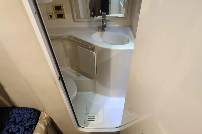 Slide: The Image of Compact bathroom in 1998 Sea Ray 630 Super Sun Sport yacht, featuring sink and toilet. - 16