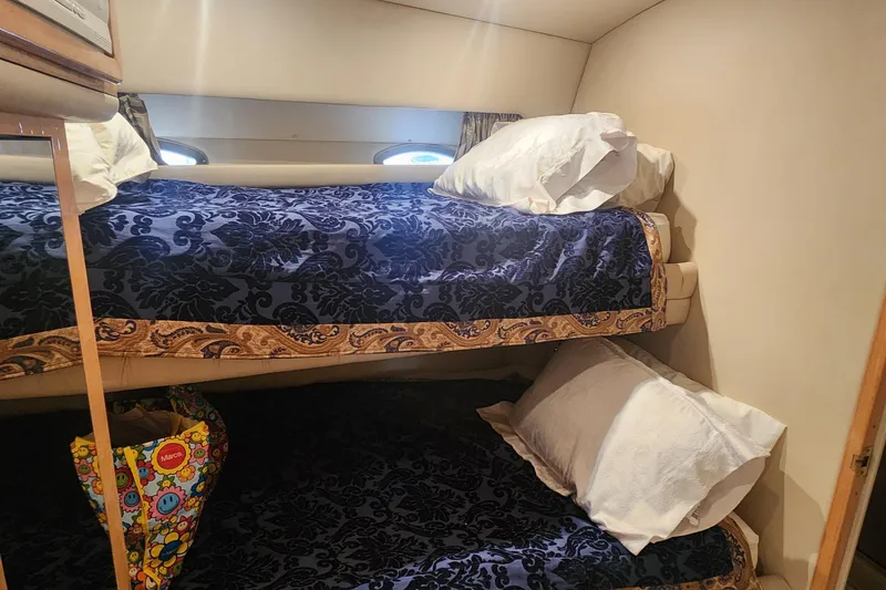 Slide: The Image of Bunk beds with blue patterned bedding in 1998 Sea Ray 630 Super Sun Sport yacht cabin. - 26