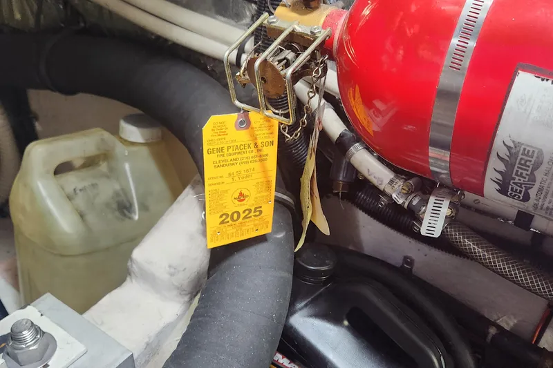 Slide: The Image of Engine room of 1998 Sea Ray 630 Super Sun Sport with fire extinguisher and maintenance tag. - 29