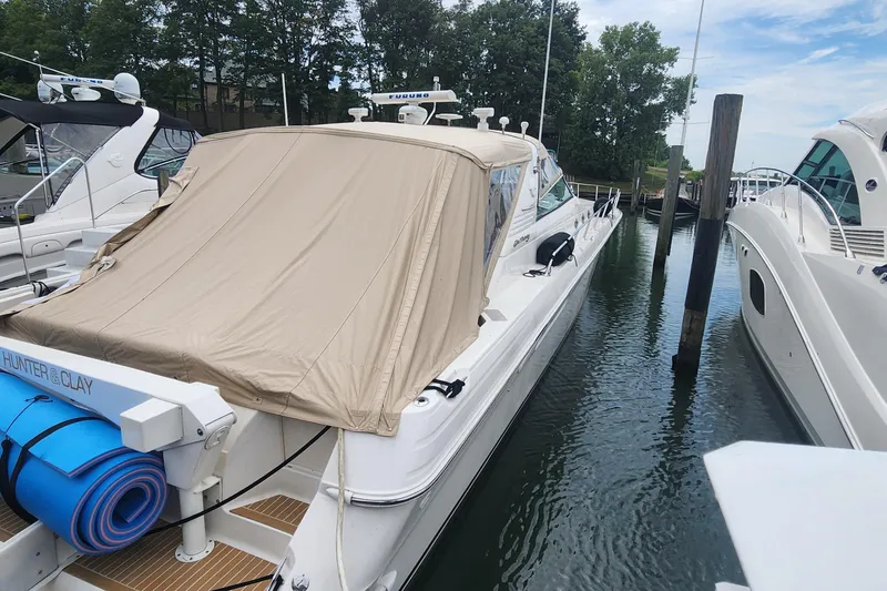 Slide: The Image of 1998 Sea Ray 630 Super Sun Sport yacht docked with beige cover. - 34