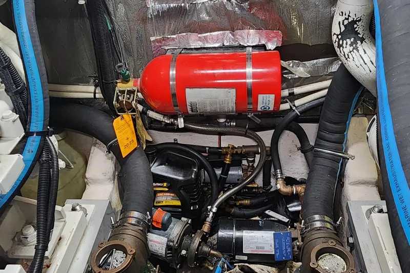 Slide: The Image of Engine compartment of a 1998 Sea Ray 630 Super Sun Sport with fire extinguisher and hoses. - 49