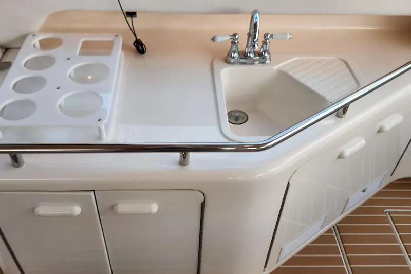 Slide: The Image of 1998 Sea Ray 630 Super Sun Sport yacht kitchenette with sink and storage cabinets. - 8