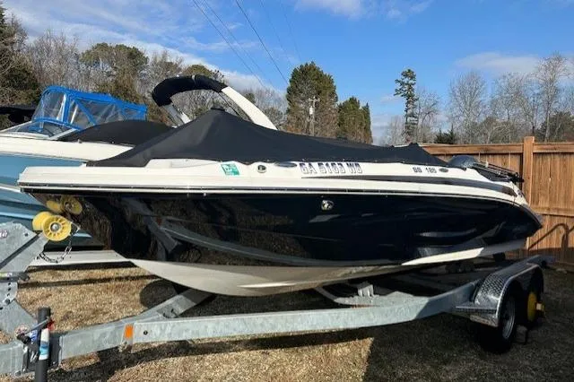 Slide: The Image of 2021 Hurricane SunDeck Sport 185 OB boat on trailer, covered, outdoors. - 13