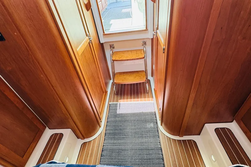 Slide: The Image of Interior of 2025 Back Cove 34O yacht with wooden finishes and steps. - 10