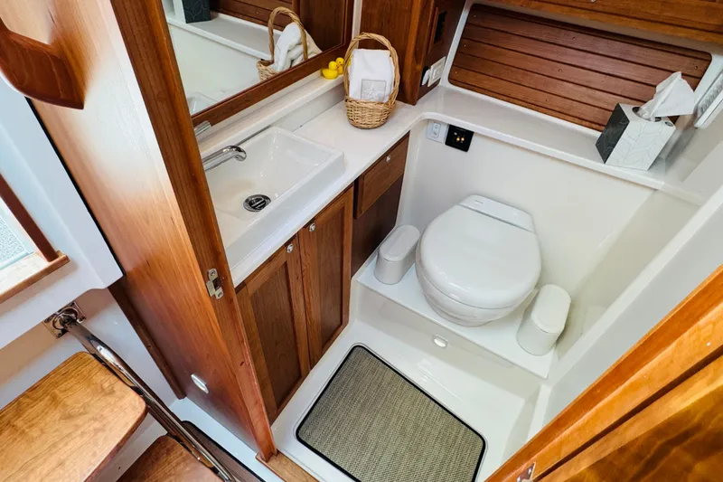 Slide: The Image of Bathroom interior of 2025 Back Cove 34O boat, featuring wooden cabinetry and modern fixtures. - 11