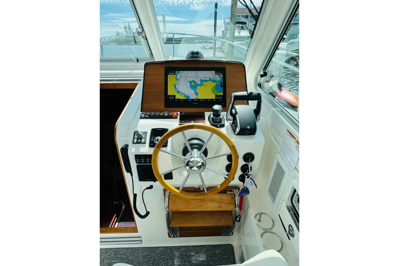 Slide: The Image of Helm of 2025 Back Cove 34O boat with navigation screen and steering wheel. - 18