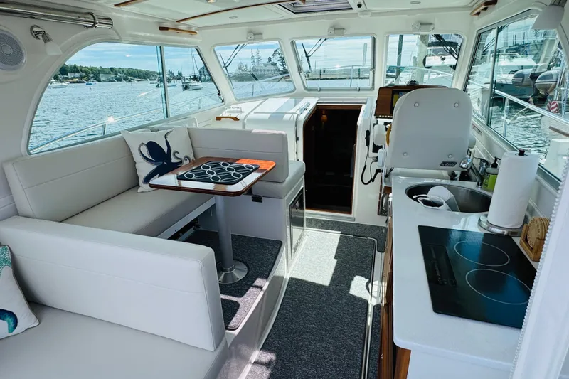 Slide: The Image of Interior of 2025 Back Cove 34O yacht with seating, table, and kitchenette. - 22