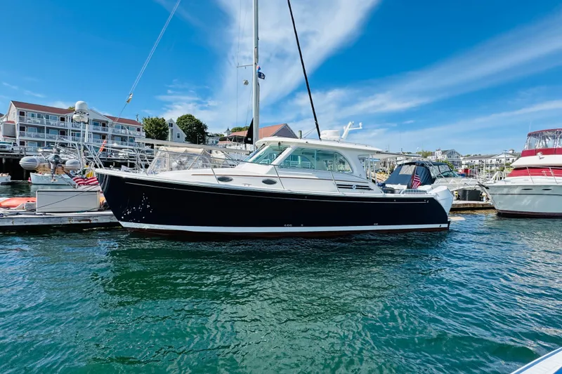 Slide: The Image of 2025 Back Cove 34O yacht docked in a marina under a clear blue sky. - 46