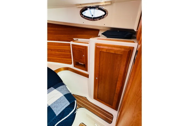 Slide: The Image of 2025 Back Cove 34O cabin interior with wooden cabinetry and nautical decor. - 5