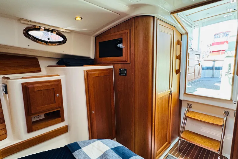 Slide: The Image of Interior of 2025 Back Cove 34O yacht, featuring wooden cabinetry and cozy design. - 6