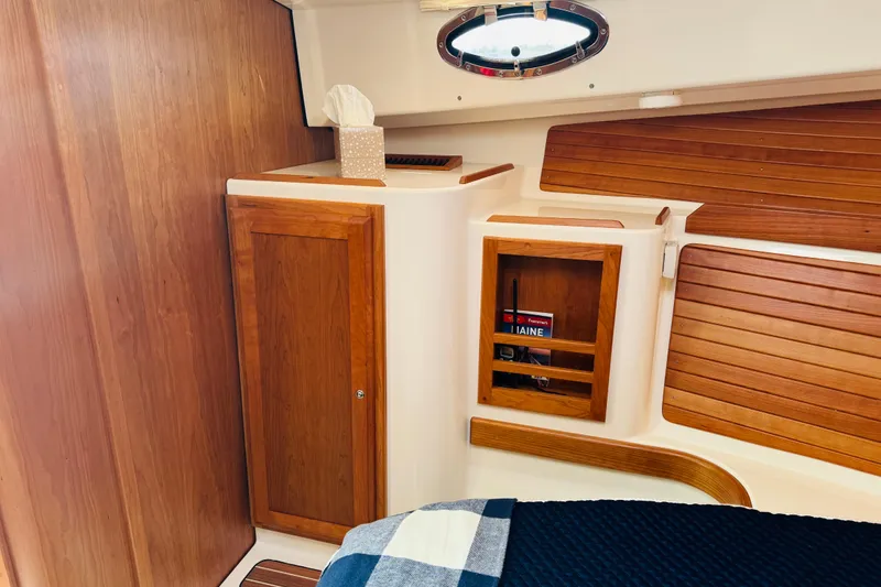 Slide: The Image of 2025 Back Cove 34O cabin interior with wooden cabinetry and nautical decor. - 7