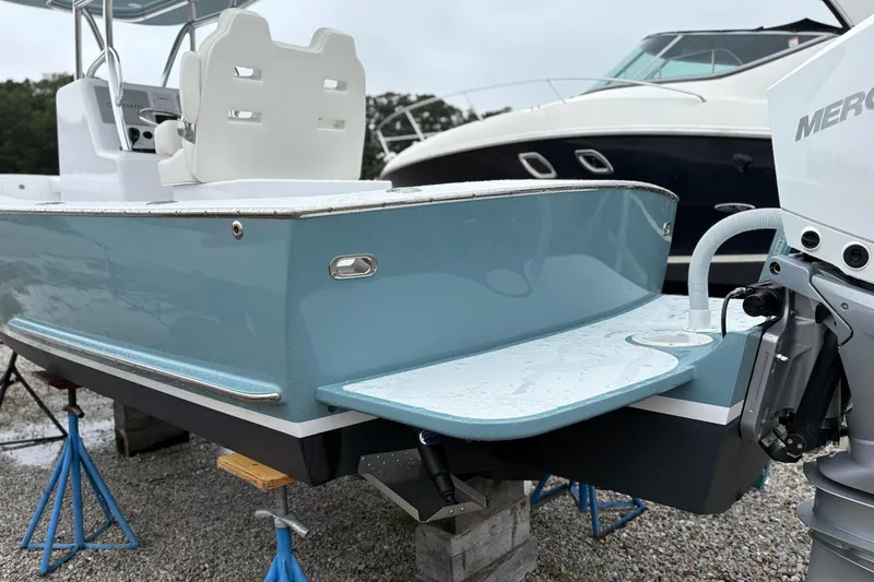 Slide: The Image of 2025 Weaver 270 boat with blue hull and white seating, displayed on stands. - 14