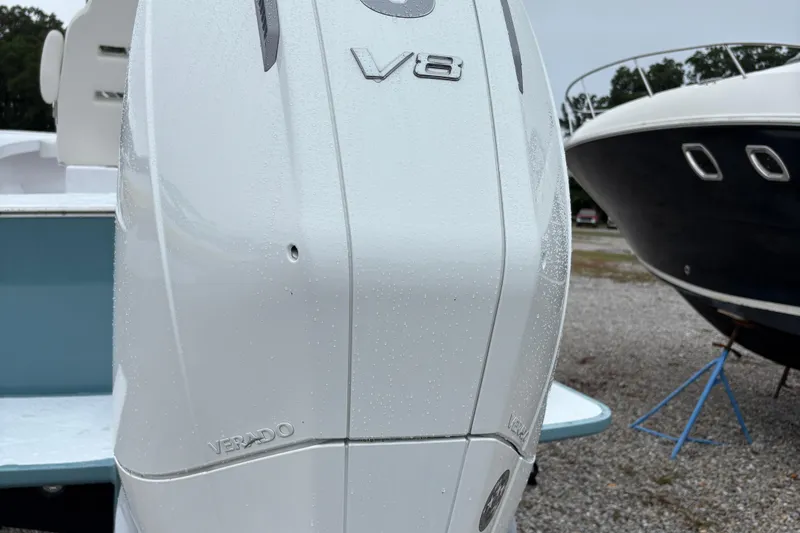 Slide: The Image of 2025 Weaver 270 boat with V8 Verado engine, parked on gravel near another boat. - 3