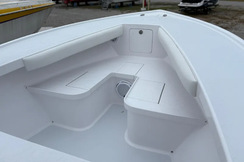 Slide: The Image of Bow seating area of 2025 Weaver 270 boat, featuring white cushioned seats and storage compartments. - 6