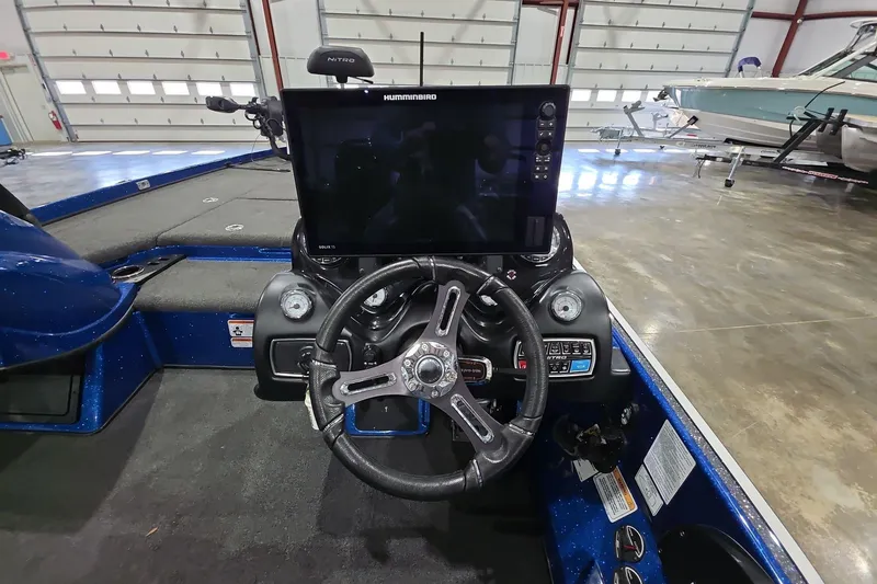 Slide: The Image of 2016 Nitro Z21 boat dashboard with steering wheel and Humminbird electronics in a garage. - 18