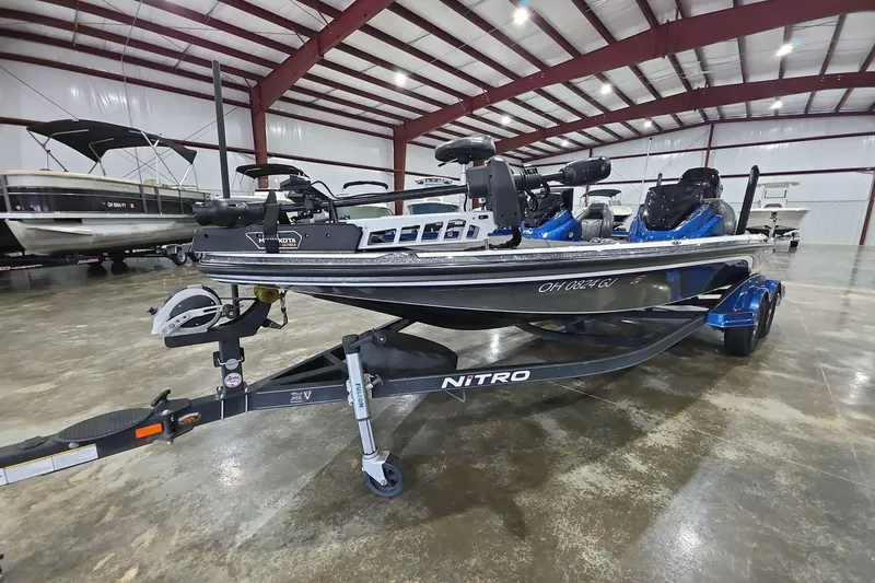 Slide: The Image of 2016 Nitro Z21 boat in a spacious indoor showroom, featuring a sleek design and trailer. - 2