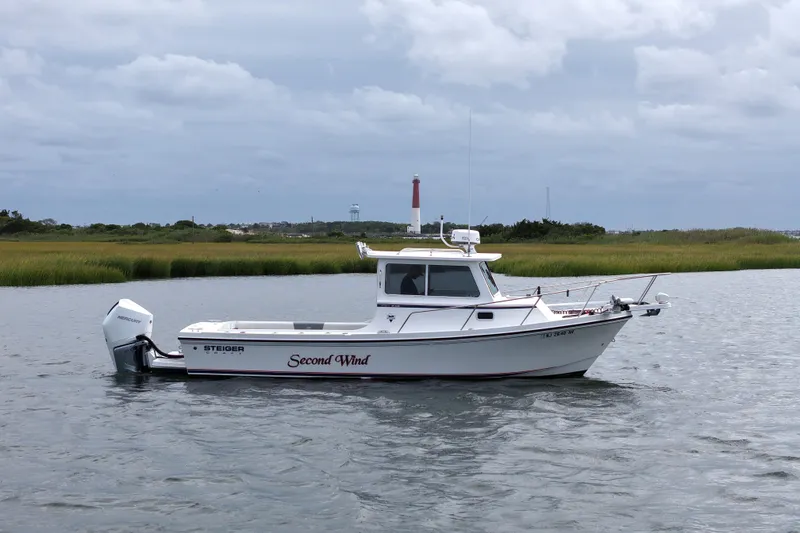 Slide: The Image of 2022 Steiger Craft 255DV Miami boat on calm water with lighthouse in background. - 10