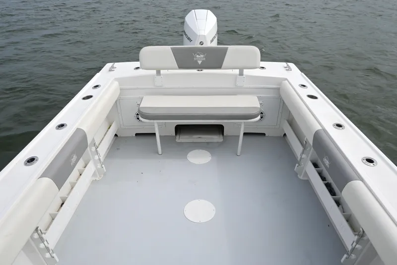 Slide: The Image of 2022 Steiger Craft 255DV Miami boat interior with seating and rod holders on the water. - 17