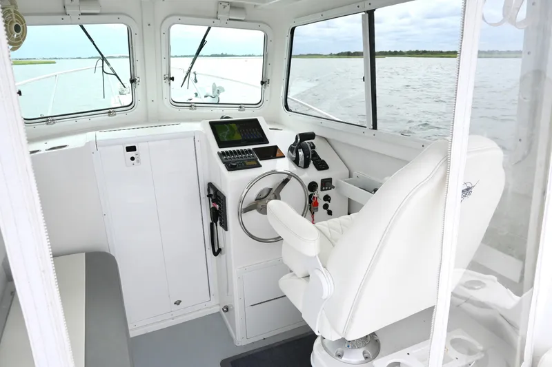 Slide: The Image of Interior of 2022 Steiger Craft 255DV Miami boat with steering wheel and navigation equipment. - 23