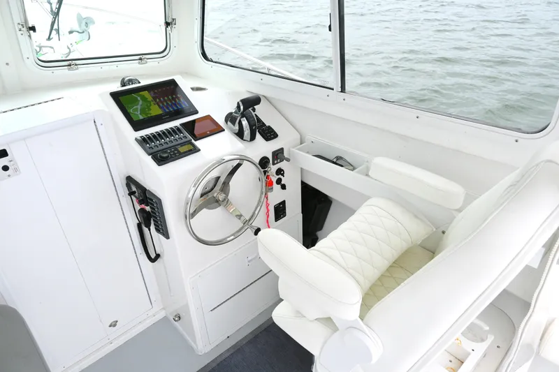 Slide: The Image of 2022 Steiger Craft 255DV Miami boat interior with steering wheel and navigation controls. - 24