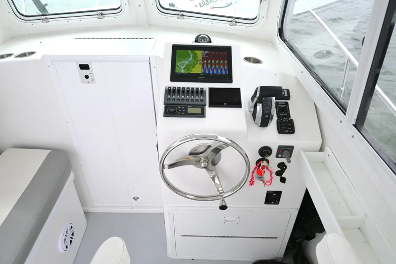 Slide: The Image of Steiger Craft 255DV Miami 2022 boat helm with navigation controls and steering wheel. - 26