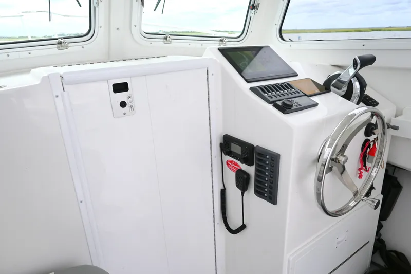 Slide: The Image of 2022 Steiger Craft 255DV Miami boat helm with steering wheel and control panel. - 28