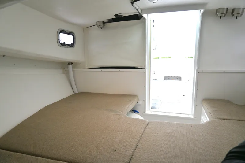 Slide: The Image of 2022 Steiger Craft 255DV Miami cabin interior with beige cushions and small window. - 36