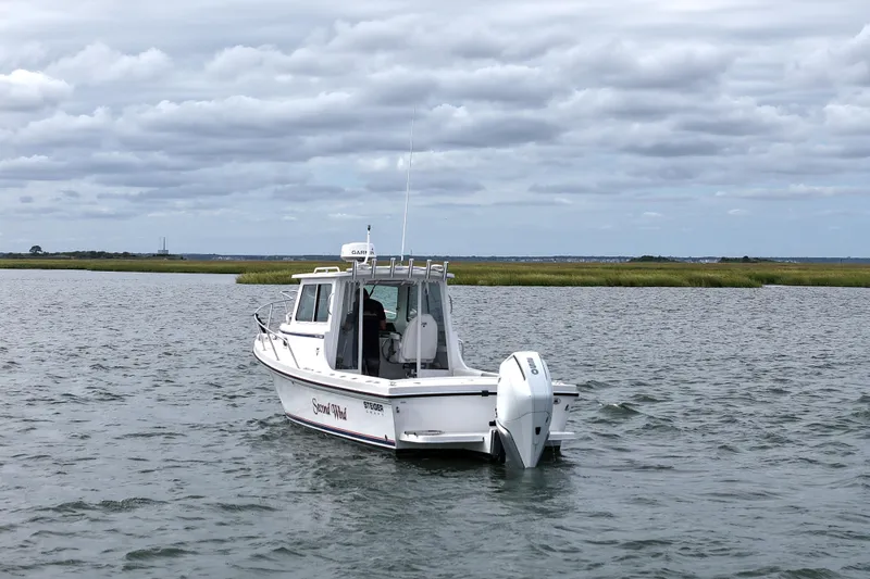 Slide: The Image of 2022 Steiger Craft 255DV Miami boat on calm water under cloudy sky. - 7