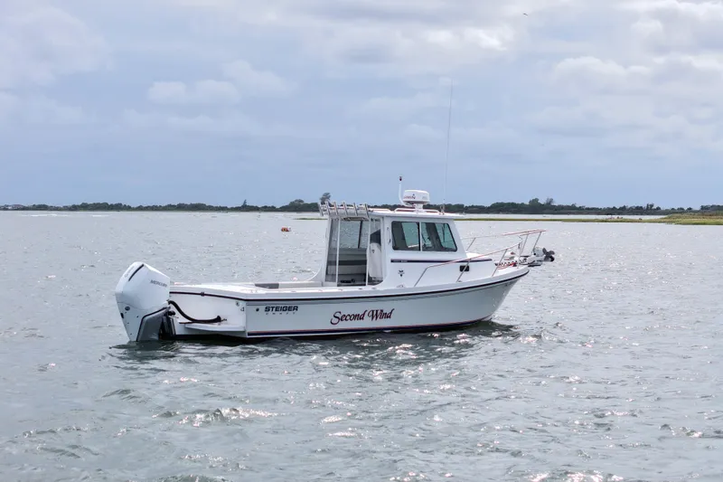 Slide: The Image of 2022 Steiger Craft 255DV Miami boat on calm water under cloudy sky. - 9