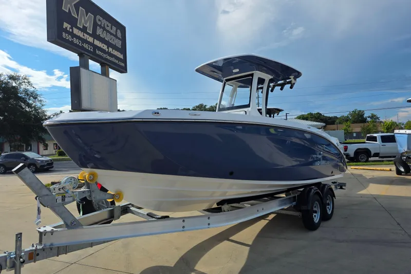 The Image of 2025 Yamaha Boats 252 FSH Sport on trailer at dealership, sunny day. - 1