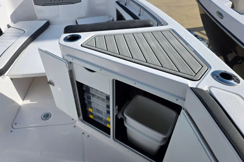Slide: The Image of 2025 Yamaha Boats 252 FSH Sport interior storage with tackle boxes and trash bin. - 11