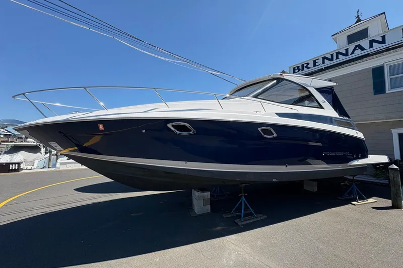 The Image of 2013 Regal 35 Sport Coupe boat on stands outside a building under clear blue sky. - 0