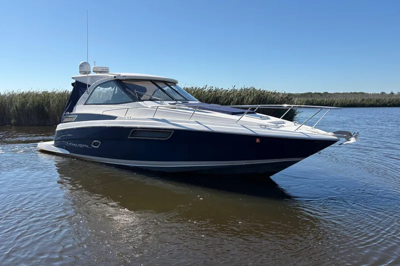 Slide: The Image of 2013 Regal 35 Sport Coupe boat on calm water, clear sky background. - 3