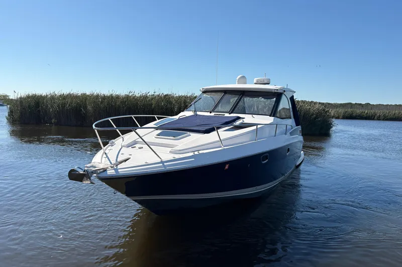 Slide: The Image of 2013 Regal 35 Sport Coupe boat on calm water, surrounded by reeds. - 4