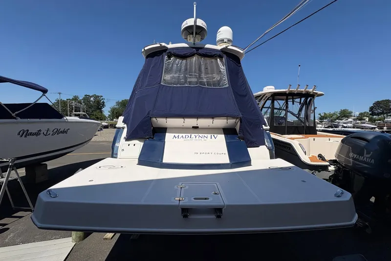 Slide: The Image of 2013 Regal 35 Sport Coupe boat with blue cover, docked alongside other vessels. - 9