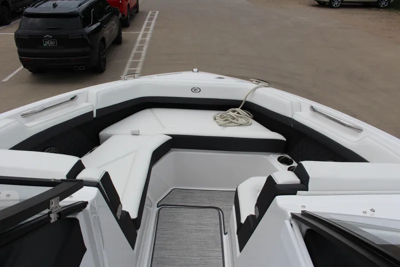 Slide: The Image of 2025 Cobalt R6 boat interior with white seating and rope, parked near vehicles. - 13