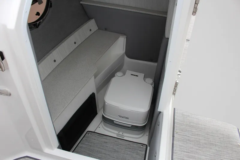 Slide: The Image of 2025 Cobalt R6 boat interior with compact marine toilet and seating area. - 20