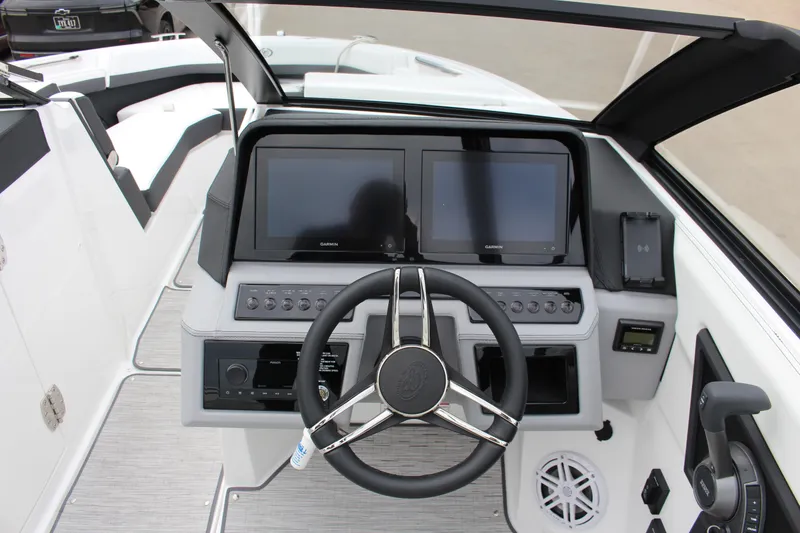 Slide: The Image of 2025 Cobalt R6 boat dashboard with dual Garmin screens and modern steering wheel. - 25