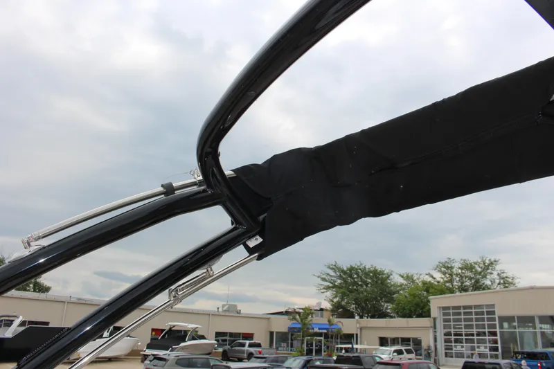 Slide: The Image of 2025 Cobalt R6 boat with sleek black frame and covered canopy, dealership background. - 26