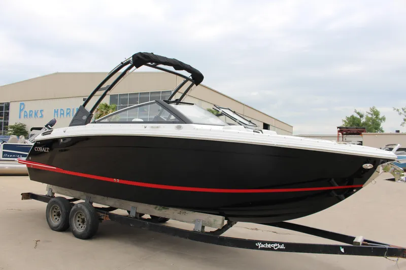 Slide: The Image of 2025 Cobalt R6 boat on trailer at marina, black with red stripe. - 3