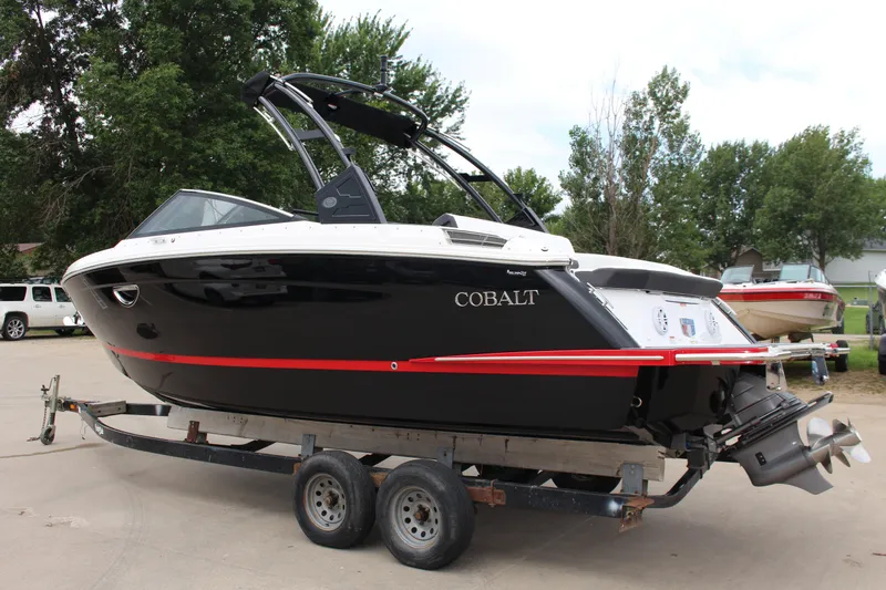Slide: The Image of 2025 Cobalt R6 boat on trailer, black with red accents, parked outdoors. - 37