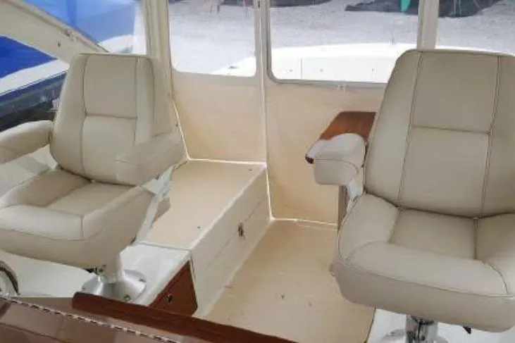Slide: The Image of 2009 MJM 29z Express boat interior with beige leather seats and wooden accents. - 11