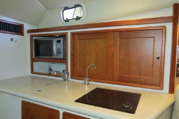 Slide: The Image of 2009 MJM 29z Express yacht interior kitchen with microwave, sink, and stove. - 19