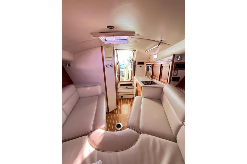 Slide: The Image of Interior of 2009 MJM 29z Express boat with seating, kitchenette, and wood accents. - 23