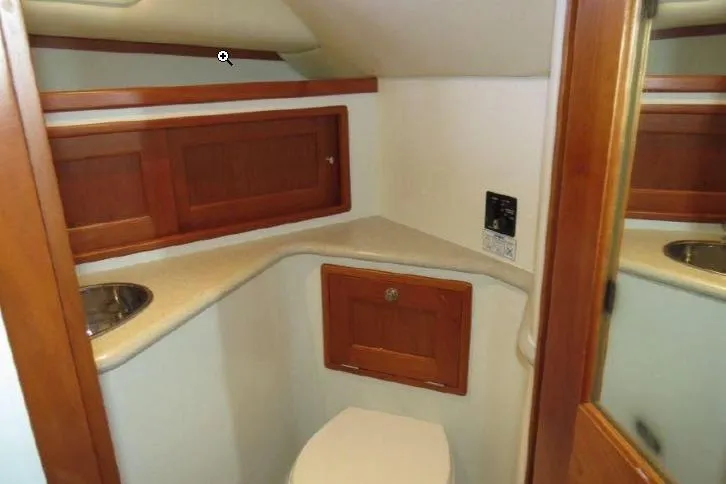 Slide: The Image of 2009 MJM 29z Express boat interior bathroom with wooden cabinets and compact design. - 26