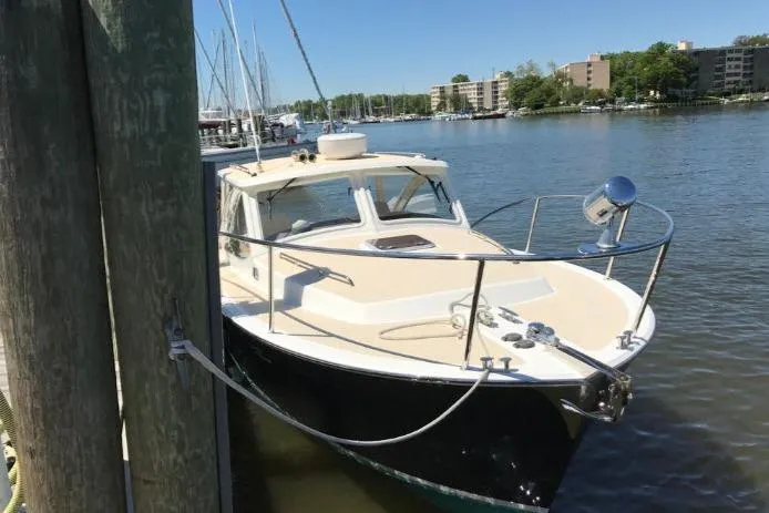 Slide: The Image of 2009 MJM 29z Express boat docked in a marina, surrounded by calm water and buildings. - 4