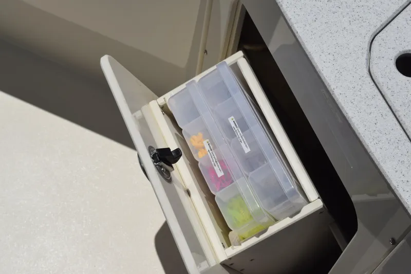 Slide: The Image of Storage compartment with organized tackle boxes on a 2021 Stingray 236CC boat. - 12